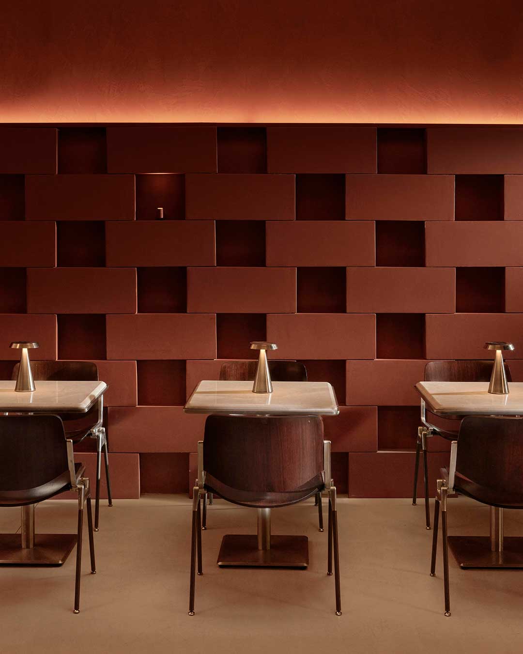 Inside AINEN, the traditional burger bar is elevated into a high-concept interior experience where light and geometry act as the primary protagonists. Set within the industrial heart of Istanbul, the design shifts the focus from the horizontal to the vertical, utilizing a faceted ceiling installation to create a sense of movement and direction. The palette is a sophisticated blend of contemporary precision and historic texture, featuring dark-stained wooden chairs by Giancarlo Piretti that will develop a rich patina over time.

As the sun sets over the Golden Horn, the atmosphere pivots. Integrated lighting recedes to create intimate shadows, and the central service axis transforms to host a DJ setup, turning the eatery into a fluid, event-driven landscape. It is a masterclass in spatial flexibility, proving that even the most constrained volumes can become dynamic social instruments.

via #urdesignmag 
architects @urbanjobs 
images @ibrahimozbunar 

#InteriorArchitecture #IstanbulDesign #HospitalityDesign #URBANJOBS #Cassina #TersaneIstanbul #SpatialDesign #LightingDesign #ModernInteriors #BurgerBar #ArchitecturalDetail #UrbanInnovation