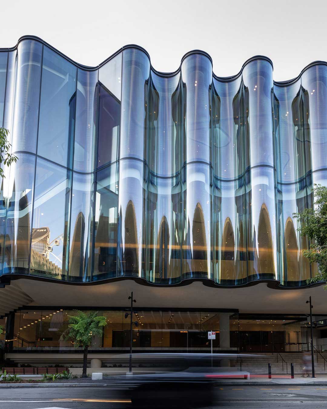 The Glasshouse Theatre emerges as a luminous addition to Brisbane’s South Bank, where the built environment meets the fluid rhythm of the river. Inspired by the prose-poetry of Aboriginal Elder Aunty Lilla Watson, the undulating glass exterior acts as a translucent veil, catching the light and reflecting the vibrant energy of the precinct. Inside, the experience shifts from airy transparency to a grounded, protective cocoon. The 1,500-seat auditorium fosters a rare intimacy, featuring rich ironbark walls and rainforest green carpets. Every detail, from the seven skylights representing Queensland’s watersheds to the floating 6-meter cantilever, reinforces a deep connection to place and a commitment to world-class performance.

via #urdesignmag 
architects @snohetta and @blightrayner 
images @christopherfrederickjones

#Architecture #Snøhetta #BlightRayner #BrisbaneArchitecture #CulturalDesign #SustainableDesign #PerformingArts #GlassArchitecture #Meanjin #UrbanInnovation #AcousticDesign #QPAC