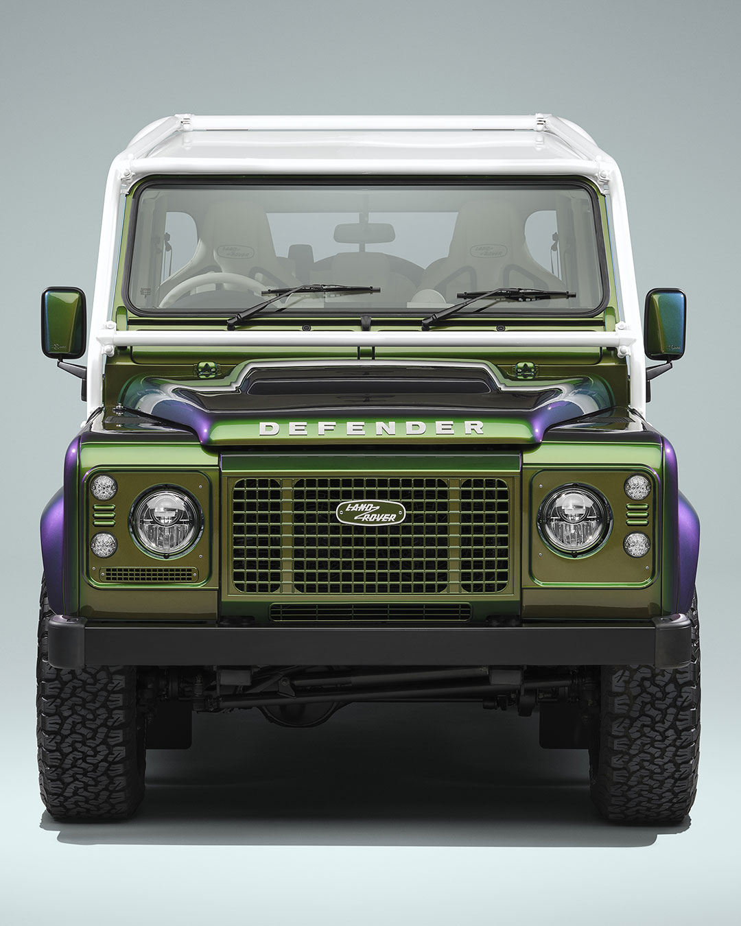 One paint, four Defenders, one client. Land Rover Classic's Spectral Green finish shifts between green, purple, and gold depending on the angle and the light — extended across the Sawtooth alloy wheels, badging, and interior fascia panels, not just the bodywork. The build debuts the 110 Double Cab Pick-Up as a Works Bespoke bodystyle for the first time, alongside a 90 Station Wagon, 90 Soft Top, and 110 Station Wagon. Close to 400 hours went into keeping that iridescent effect consistent, inside Land Rover Classic's own paint facility. images courtesy of @land_rover_defender urdesignmag.com — link in bio #LandRoverClassic #DefenderV8 #WorksBespoke #SpectralGreen #ClassicDefender