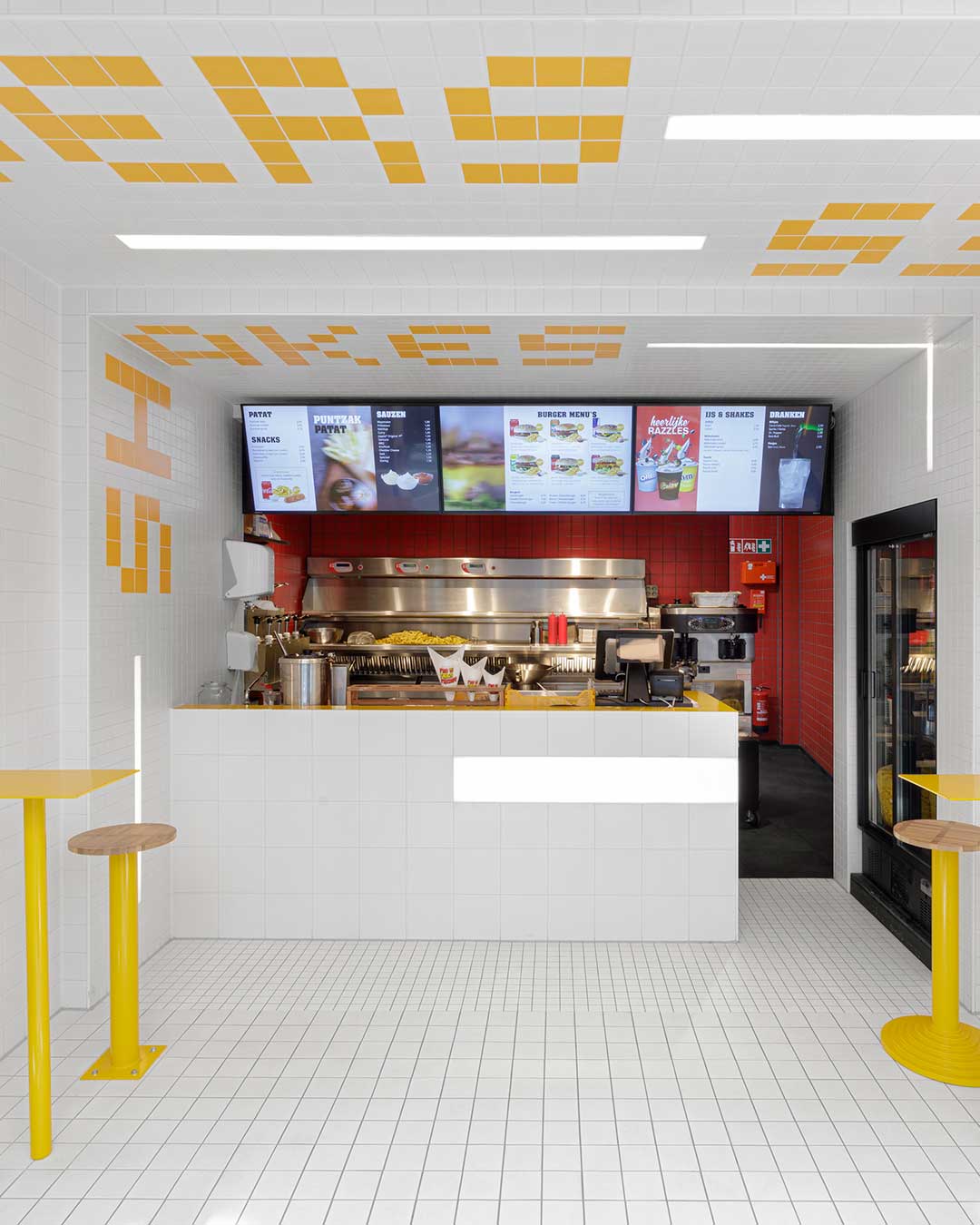 A shrinking tile grid — 20cm squares at the entrance, down to 5cm near the counter — pulls customers through Fab Fries Freddy's 35-square-meter footprint in Amsterdam. Ninetynine built the optical trick entirely out of matte ceramic, no digital signage required. The prep area breaks the sequence with signal red, the visual payoff at the end of a tunnel made of nothing but tile. Design: @ninetynine_amsterdam — Jeroen Vester, Giulia Cosenza
Photography: @ewouthuibers urdesignmag.com — link in bio #Ninetynine #InteriorDesign #Amsterdam #TileDesign #FastFoodDesign
