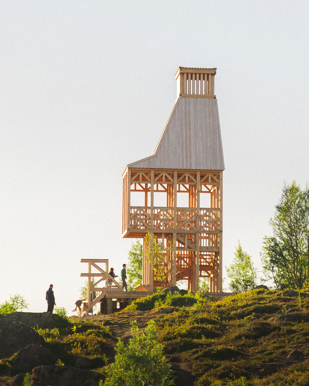 No metal joins this timber tower above Kola Bay — every X-brace is doing the fastener's job instead. Evgeny Makarenko's Timber Architecture Workshop built this observation deck in Murmansk using wood joinery alone, engineered to survive Arctic winters without a single metal connector.  The tower tapers toward its top, the one gesture that reads as lighthouse rather than crane, while sunlight through the slatted walls turns the interior staircase into a second, moving pattern. From the upper deck, the view over the bay is the payoff the small structure down the hill was built to earn.  architects: Evgeny Makarenko / Timber Architecture Workshop
photography: Alexey Arushanyan, Alexey Malenchik, Tatiana Okuneva  urdesignmag.com — link in bio  #KolaBay #Murmansk #TimberArchitecture #ArcticDesign #WoodJoinery