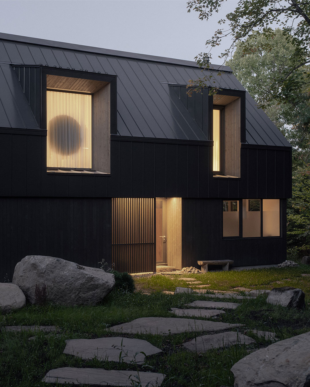 No load-bearing walls on the two main floors of Chalet Moraine, a 2025 lake house in Quebec's Laurentians. Contractor Gestion Séquence named their absence among the project's hardest challenges, saying the streamlined result took extensive calculation. Montreal-based Appareil Architecture set the interior's service rooms free of the structure entirely, as freestanding volumes modeled on the glacial erratic boulders scattered through the surrounding forest. From the water, the house still reads as a plain rectangle under a gabled roof, the simplest form of French-Canadian vernacular architecture. Appareil Architecture @appareilarchitecture — Chalet Moraine — Laurentians, Quebec
Photography: Félix Michaud @michaudfelix_photo urdesignmag.com — link in bio #architecture #laurentians #quebec #lakehouse #contemporaryarchitecture
