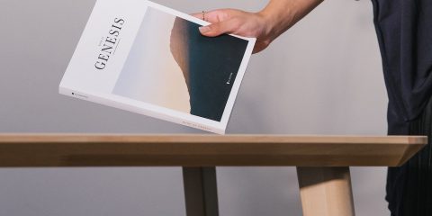 A female hand takes a book from a table