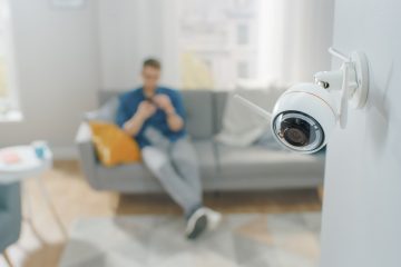 Close Up Object Shot of a Modern Wi-Fi Surveillance Camera with Two Antennas on a White Wall in a Cozy Apartment