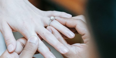 Close-up on hands exchanging an engagement ring