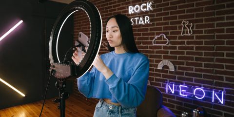 Content creator records video against a neon background