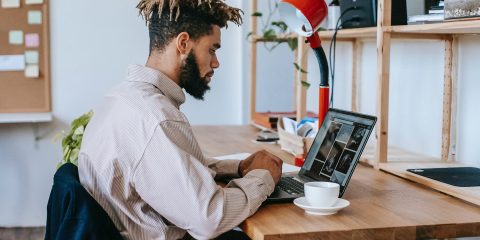 Black man remote worker using computer in home office