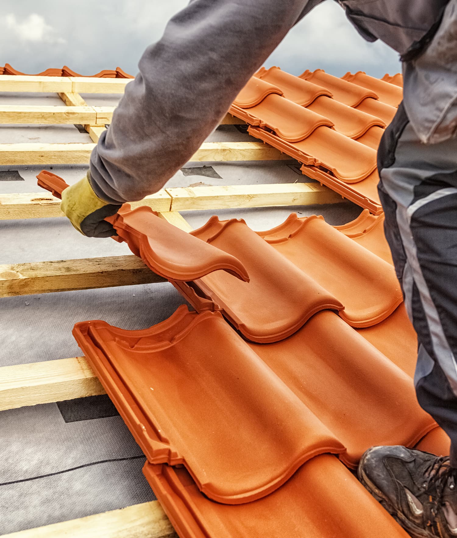 Roofer installing clay roof tiles