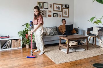 Maid cleans carpet with vacuum cleaner