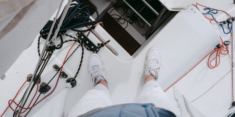 Person in Blue Pants and White Sneakers on a Boat
