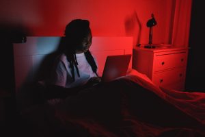 Girl watches netlfix on her laptop in bed