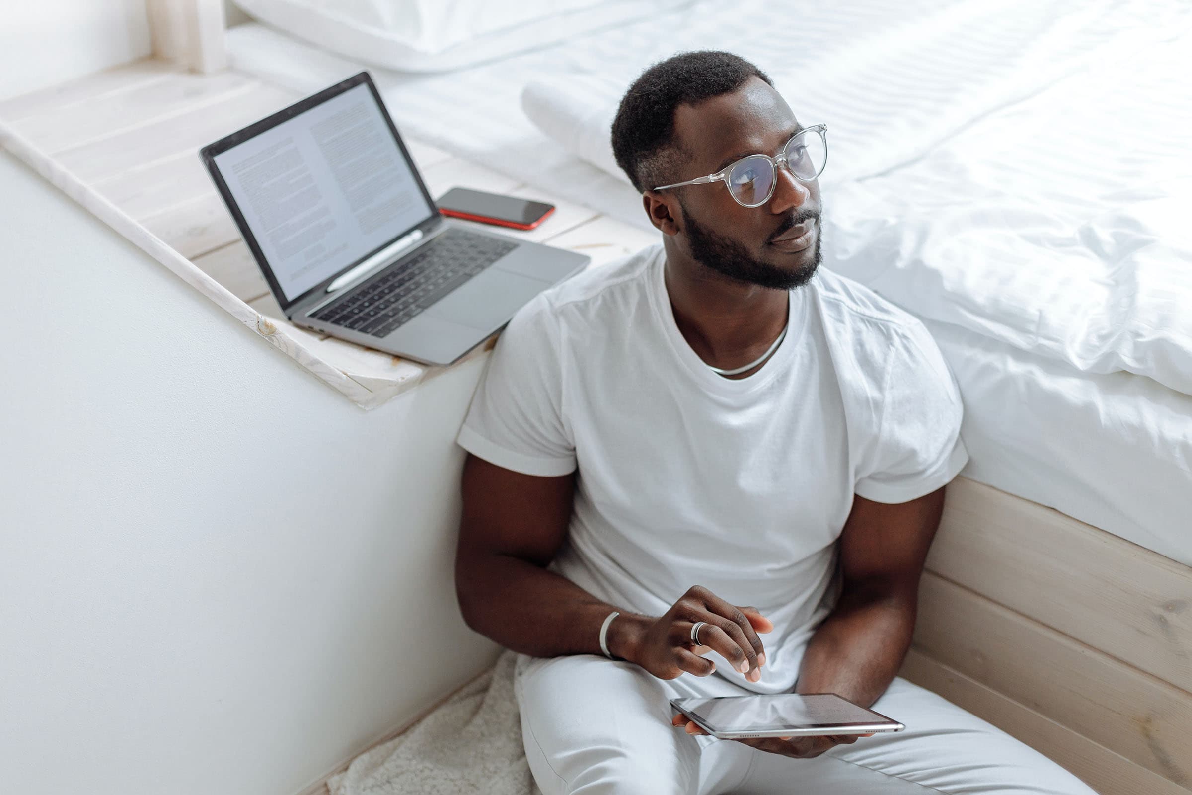 Man in White Crew Neck T-shirt Wearing Eyeglasses While Working on Laptop