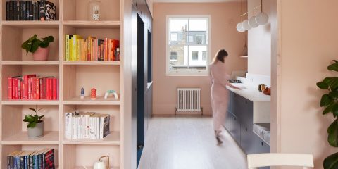 Woman in a kitchen with blue cabinets and pink walls
