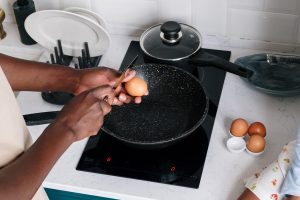 A Person Cracking Eggs with a Knife