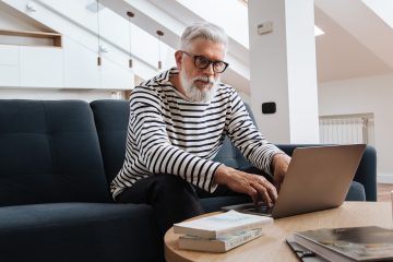 Man Sitting and Working with Laptop on Table