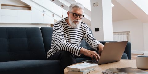 Man Sitting and Working with Laptop on Table