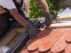 Hands of roofer laying tile on the roof