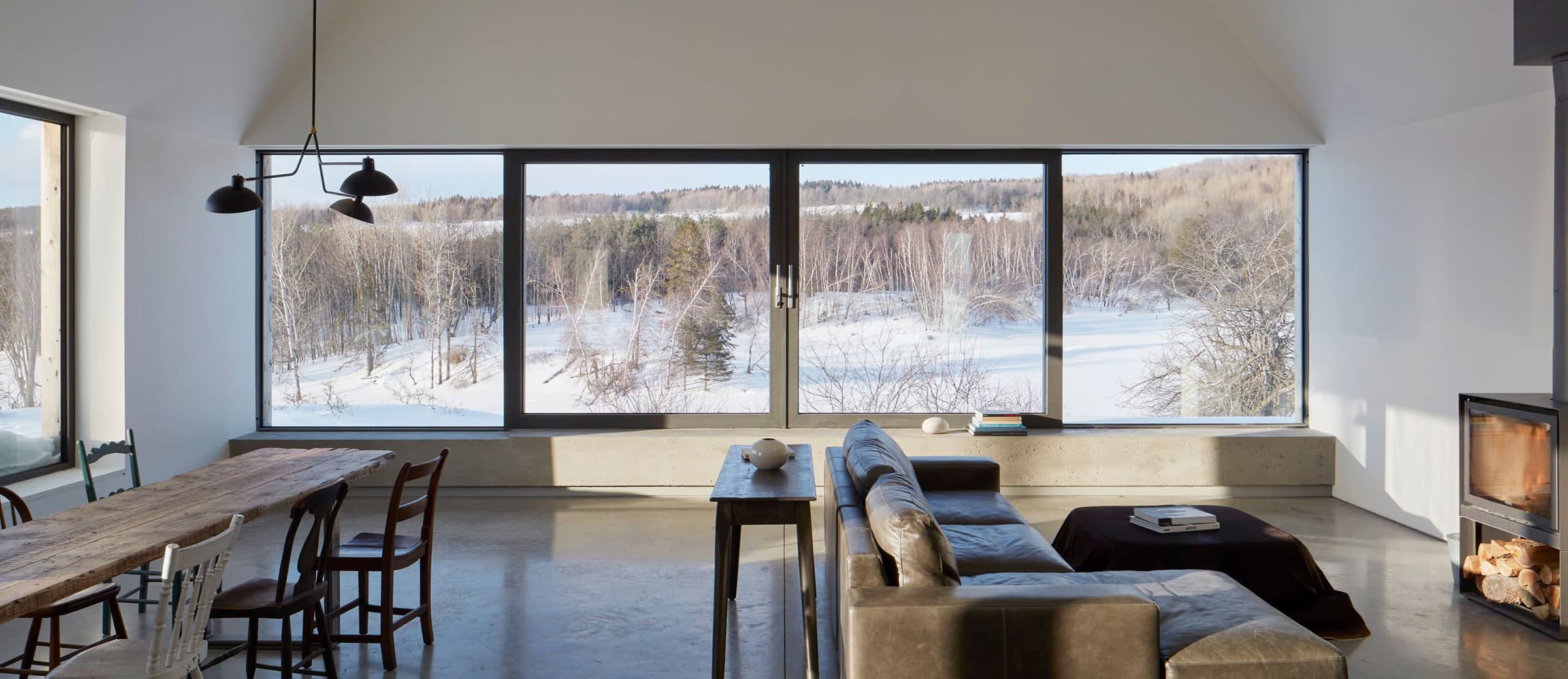 Living area with large windows overlooking snowy landscape