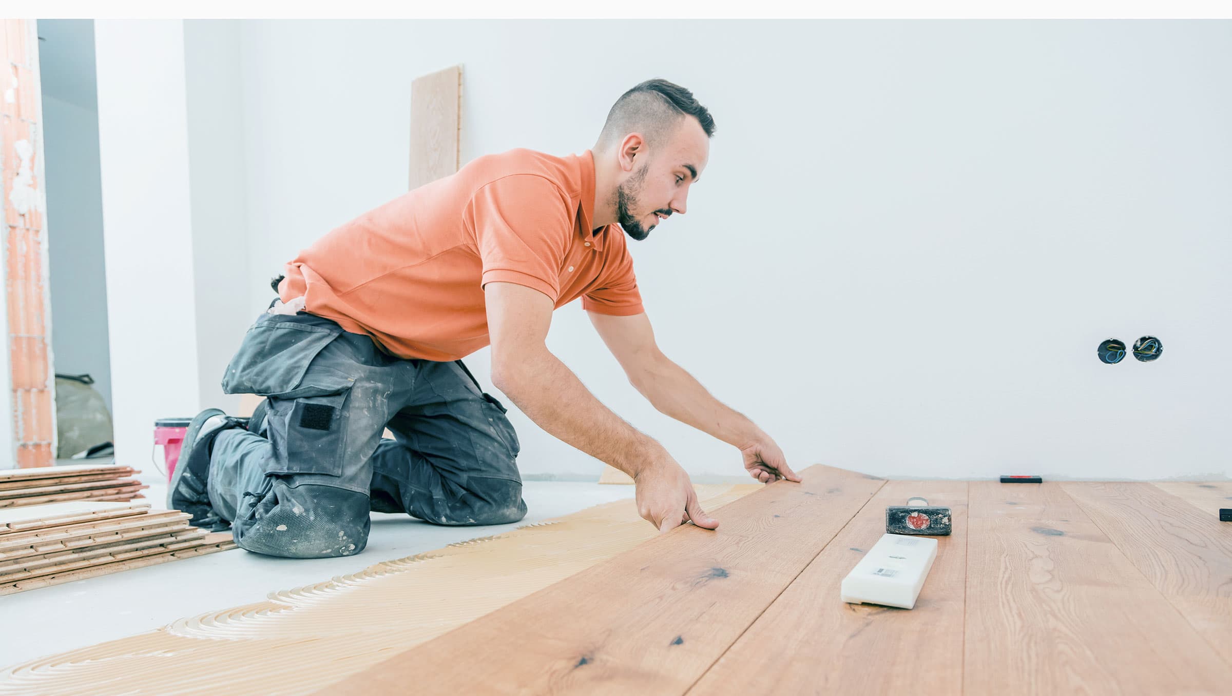 A Male Worker install wood floor on a house