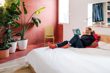 Man lying on bed reading a book