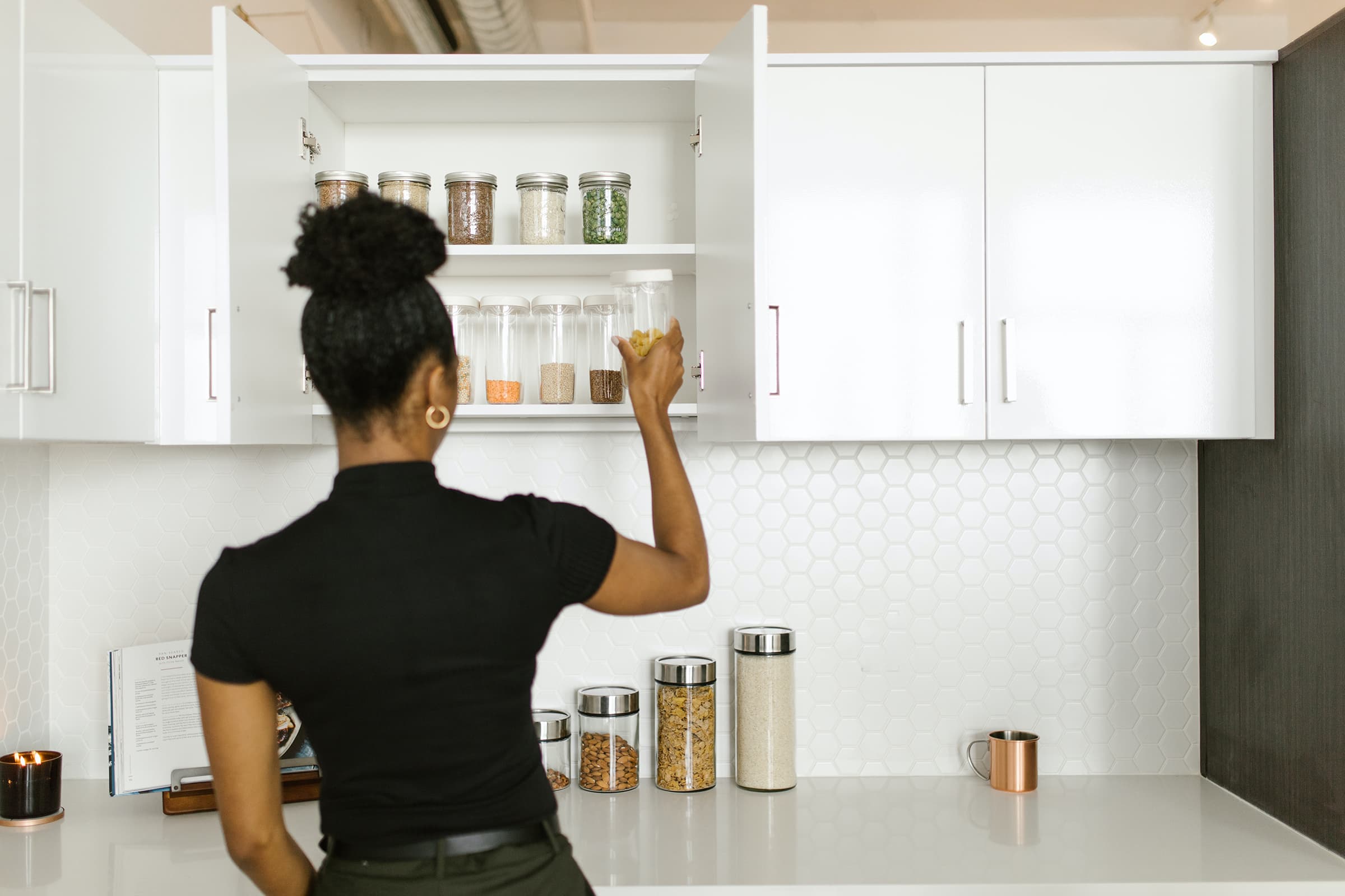 Afro-American woman tidies up the pantry