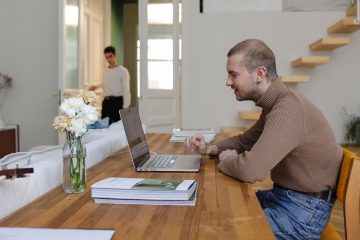 A Man Using a Laptop in a Home Office