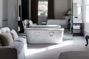 Luxurious bedroom with freestanding bathtub in white marble