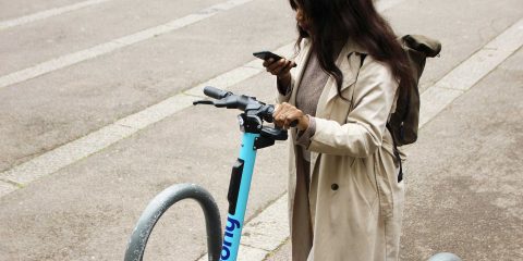 Woman rents electric scooter via an app from her smartphone