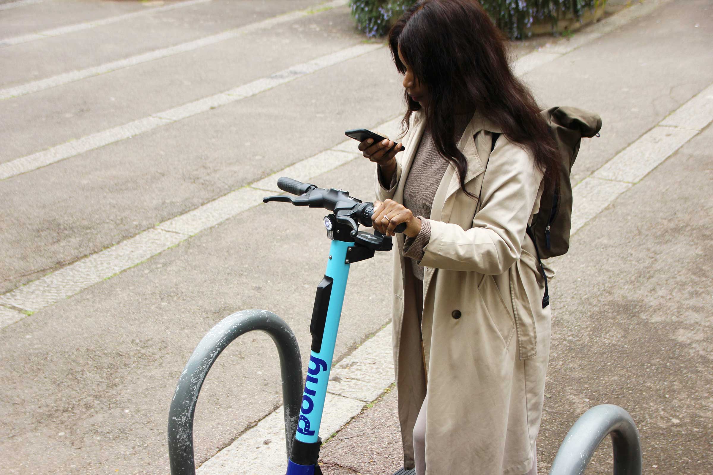 Woman rents electric scooter via an app from her smartphone