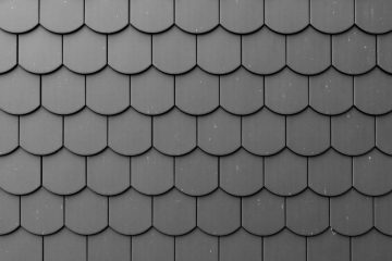 Fragment of a black roof of a private house made of shingles