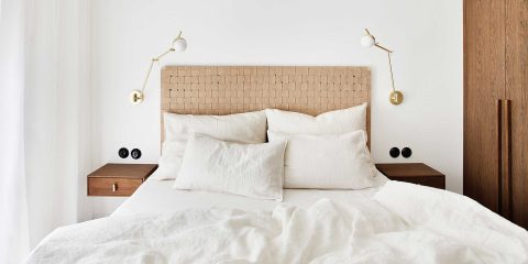 Bedroom with bedside tables and lamps hanging on the wall