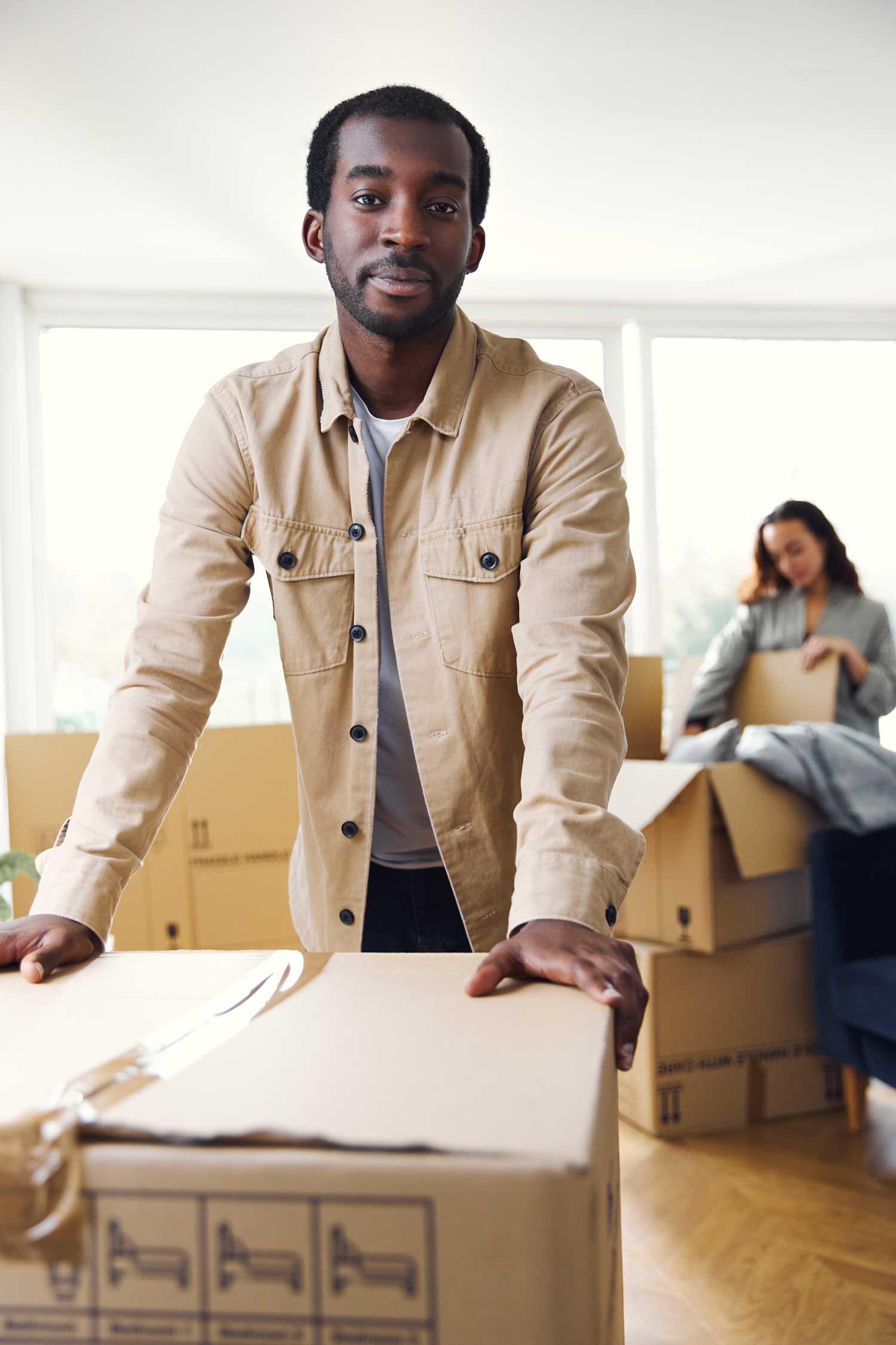 Young couple in living room at home packing boxes to put in portable storage unit