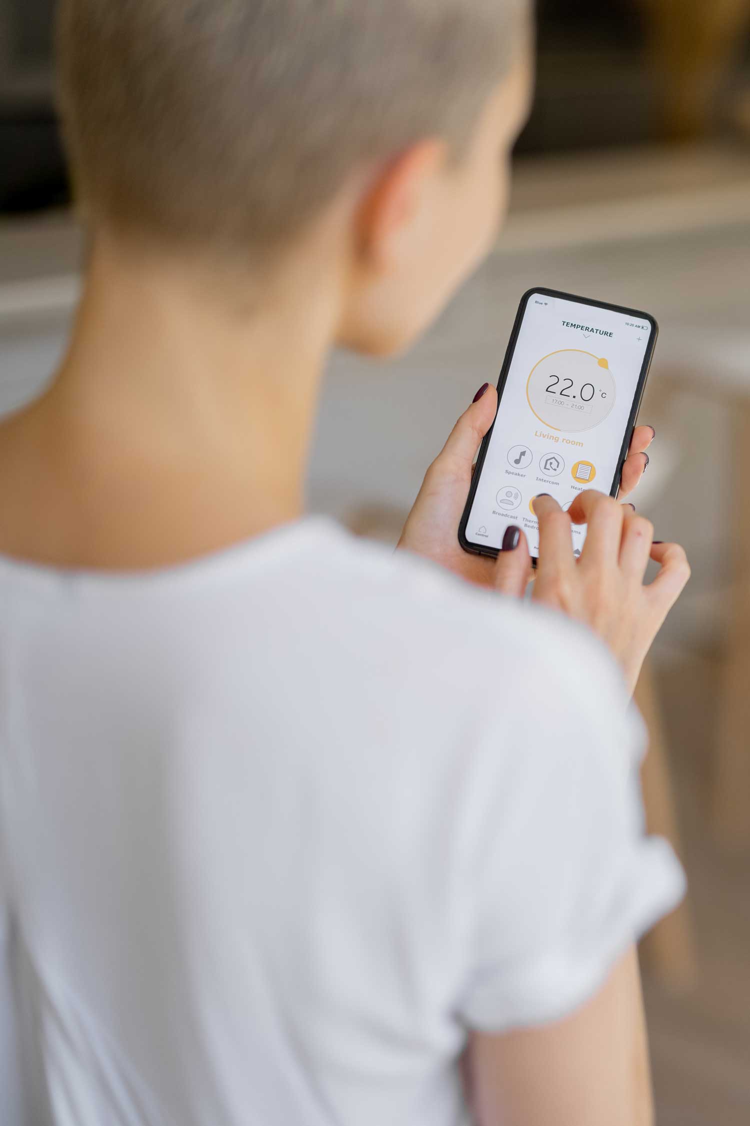 Man and woman controlling heating system with mobile app at home
