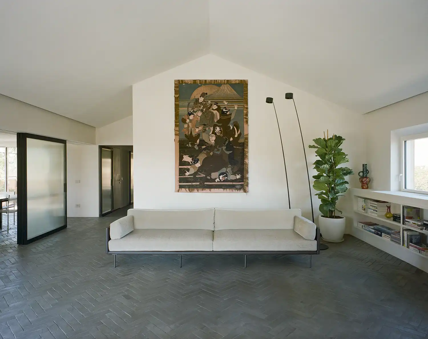 PAROS Architettura Redefines Roman Elegance with Casa ANCE’s Hybrid Guesthouse-Meeting SpaceIn Rome’s historic neighborhood near Villa Torlonia, PAROS architettura has transformed a disjointed early 20th-century penthouse into Casa ANCE - a sophisticated hybrid space that effortlessly blends residential comfort with professional functionality. The project, commissioned by Italy’s national association of building companies, reimagines the 140-square-meter apartment and its 160-square-meter terrace as both a guest residence and meeting venue, creating a compelling case study in adaptive reuse. The original layout presented significant challenges - three separate units with a complex pitched roof structure and varying ceiling heights created a fragmented interior. PAROS architettura’s solution was to completely rework the spatial organization, establishing a clear distinction between public reception areas and private zones while preserving the building’s historic character. The design team saw opportunity in the existing architectural constraints, using them to inform a thoughtful, contemporary intervention. At the heart of the renovation is a stunning open-plan public area where the original roof beams remain exposed, creating visual drama and a sense of continuity. A sliding iron-and-glass partition system provides flexible division of space, allowing the dining and meeting area to be either incorporated into the main flow or closed off for private functions. This innovative approach maintains spatial fluidity while accommodating different uses. The material palette speaks to the building’s industrial heritage while achieving modern elegance. Raw stone surfaces, microcement floors, and custom-designed wood-and-iron furnishings create a tactile, minimalist aesthetic. PAROS architettura’s careful selection of natural materials reflects both the client’s identity in the construction industry and Rome’s architectural legacy, resulting in spaces that feel simultaneously contemporary and timeless.