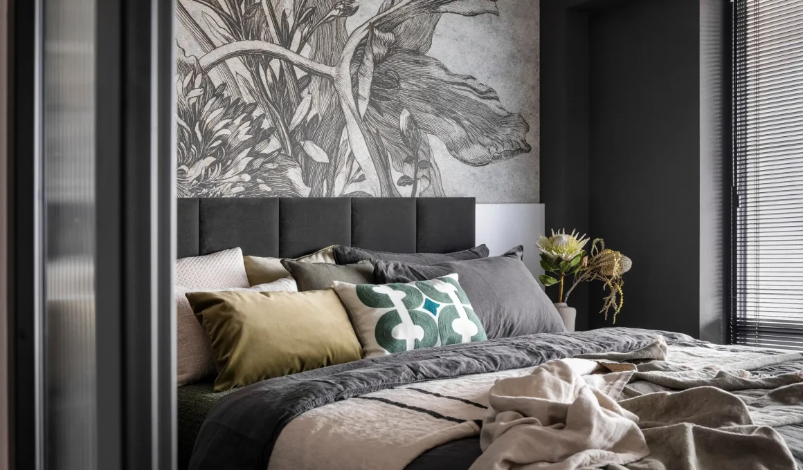 Eclectic bedroom with distressed wood furniture, layered textiles, and asymmetrical decor showcasing the shambolism design trend.