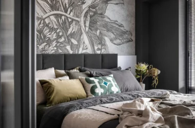 Eclectic bedroom with distressed wood furniture, layered textiles, and asymmetrical decor showcasing the shambolism design trend.