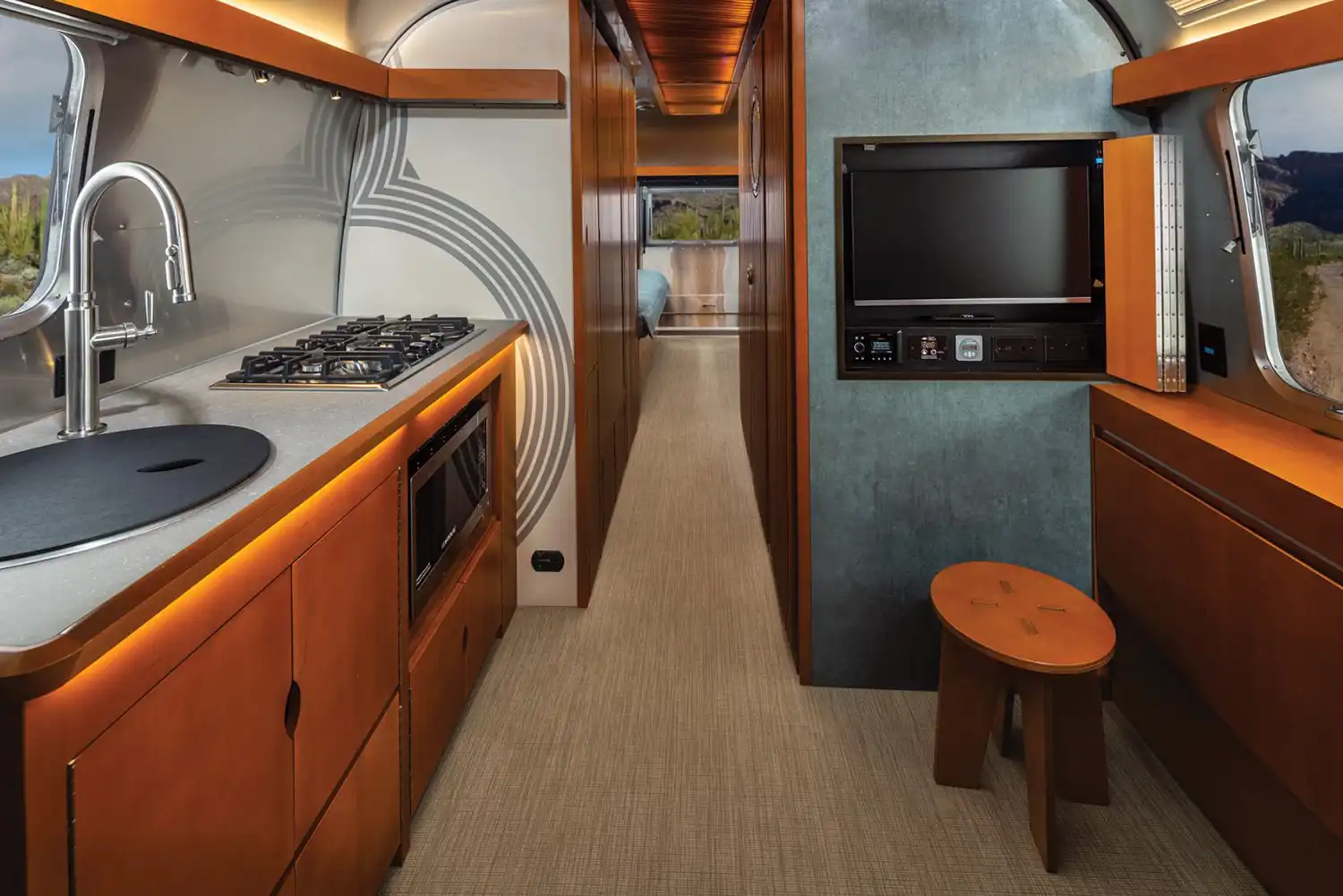 Airstream x Frank Lloyd Wright travel trailer kitchen with high-end appliances, Wright-inspired cabinetry, and minimalist functional design for mobile living.