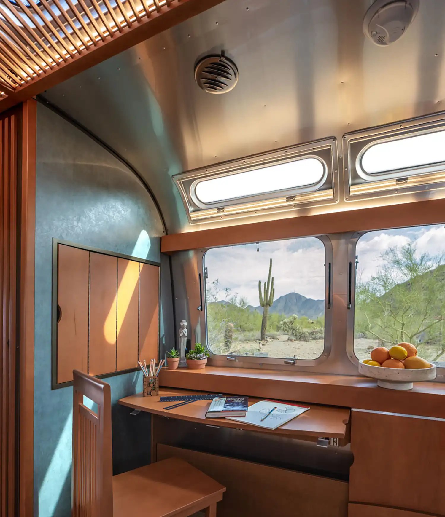Rear angle of the limited-edition Airstream Usonian trailer with horizontal lines, low-profile silhouette, and panoramic windows for indoor-outdoor connection.
