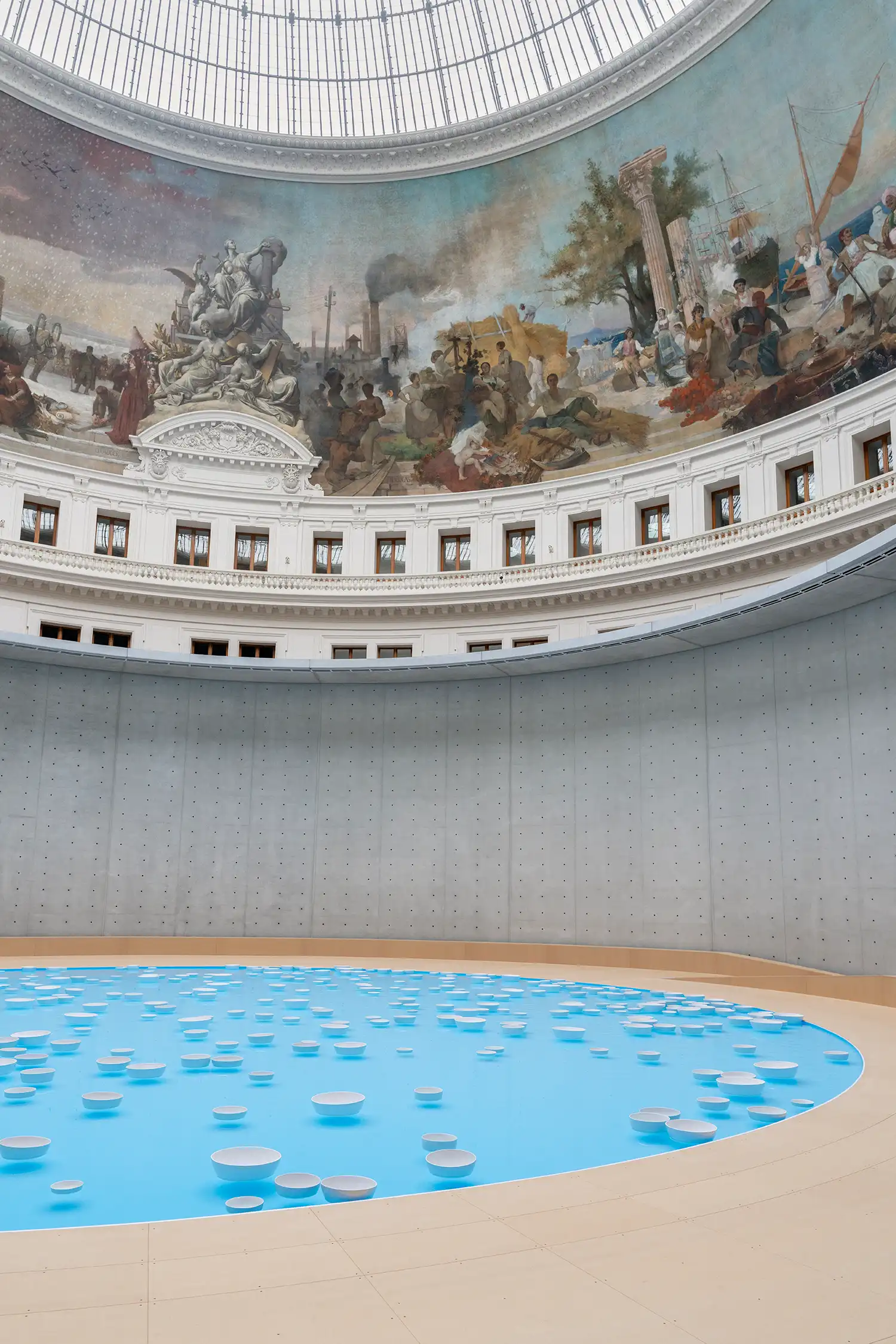 Bourse de Commerce Paris neoclassical rotunda illuminated by natural light, reflecting Céleste Boursier-Mougenot’s clinamen water installation below the dome.