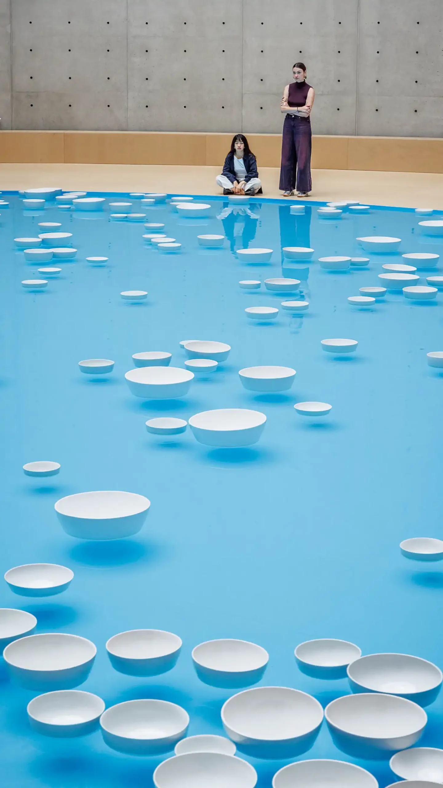 Close-up of white ceramic bowls colliding in Céleste Boursier-Mougenot’s clinamen installation, creating acoustic vibrations on water at Pinault Collection Paris
