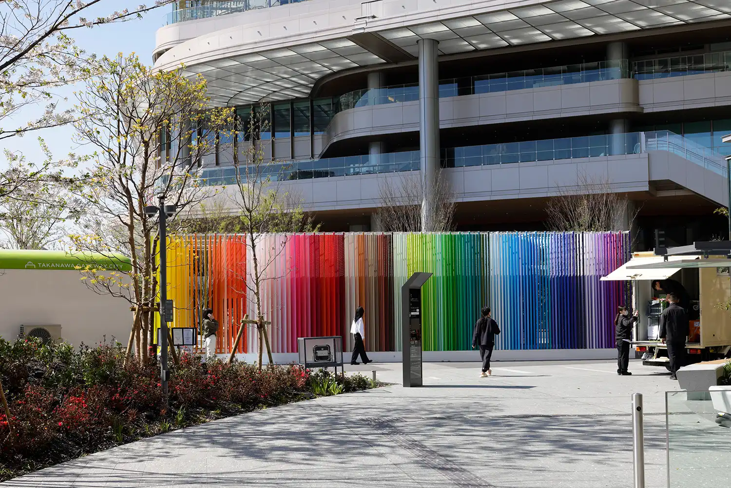 Side perspective of 2,400 vertically suspended colored lines creating immersive pathway in Moureaux's Tokyo public art.