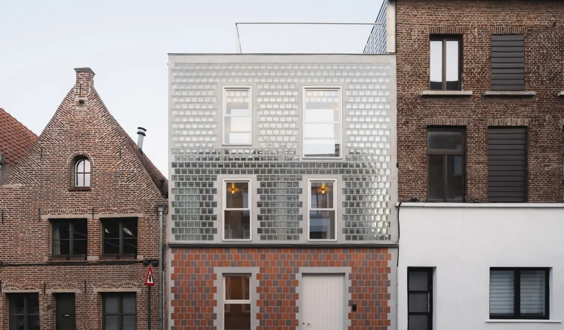 Glass brick house facade in Ghent, Belgium: Sustainable CLT home on narrow lot with double-skin insulation & historic context.