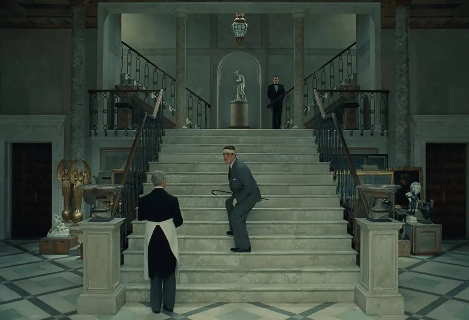 Cinematic still from "The Phoenician Scheme" showcasing retro-futuristic architecture and detailed production design.