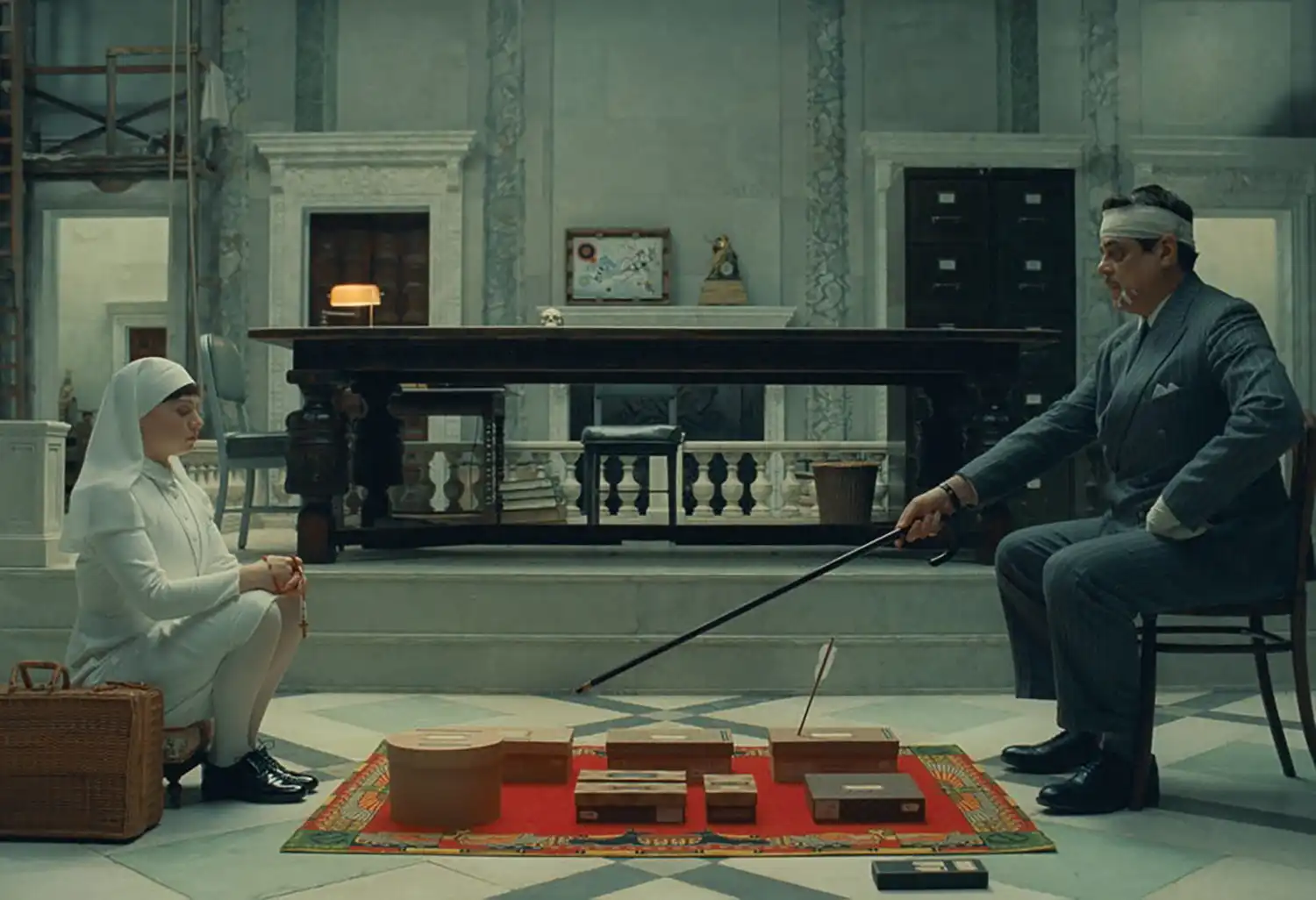 Cinematic still from "The Phoenician Scheme" showcasing retro-futuristic architecture and detailed production design.