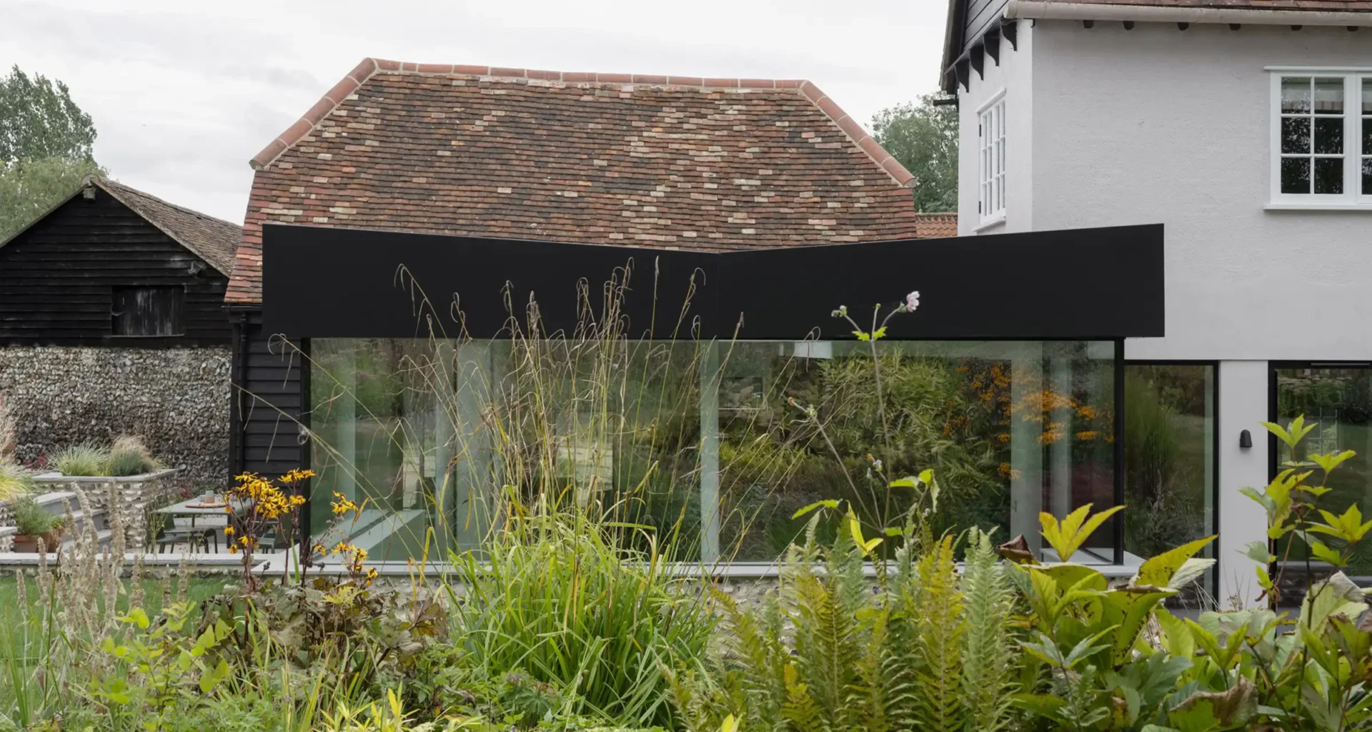 Flint Farm Restoration: Grade II Hertfordshire Farmhouse with Knapped Flint & Black Steel Extension by Will Gamble Architects