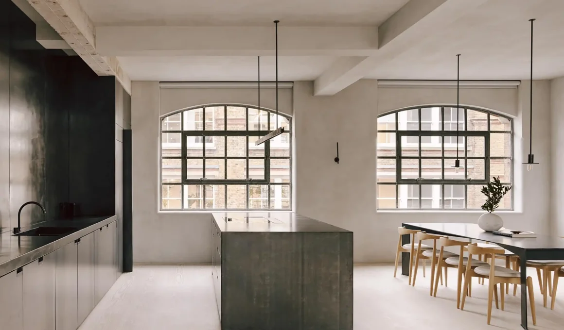 McLaren.Excell The Factory London industrial loft conversion featuring exposed structural concrete beams, blackened steel staircase, Douglas fir flooring.