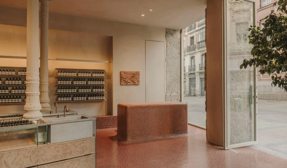 Interior of Aesop Las Salesas Madrid store by Ciszak Dalmas featuring sculptural Trencadís mosaic walls, dappled light through Catedral glass, and the floating portico with Silvestre Granito counter.