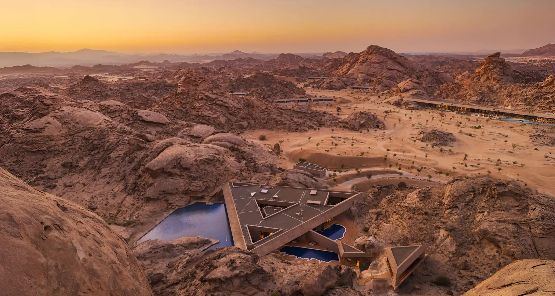 Aerial view of Desert Rock Resort in Saudi Arabia's Hejaz mountains - camouflaged sustainable architecture by Oppenheim blending into tectonic landscape