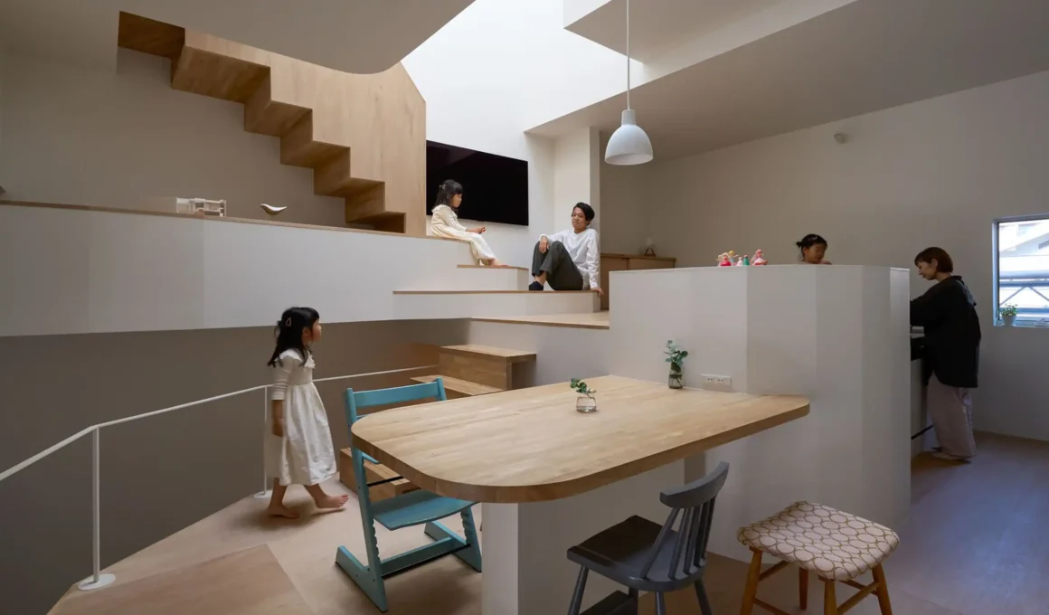 Family living area in Fujiwaramuro Architects' House in Hirano, Osaka, bathed in skylight illumination amid terrain-inspired levels.