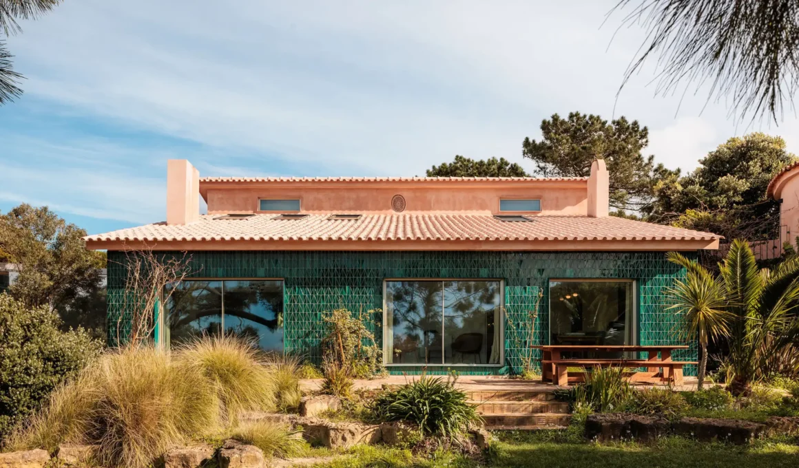 House Azóia AIP by João Tiago Aguiar Arquitectos: high-reflectivity glass facade mirroring Azóia Portugal cliffs and Atlantic Ocean.